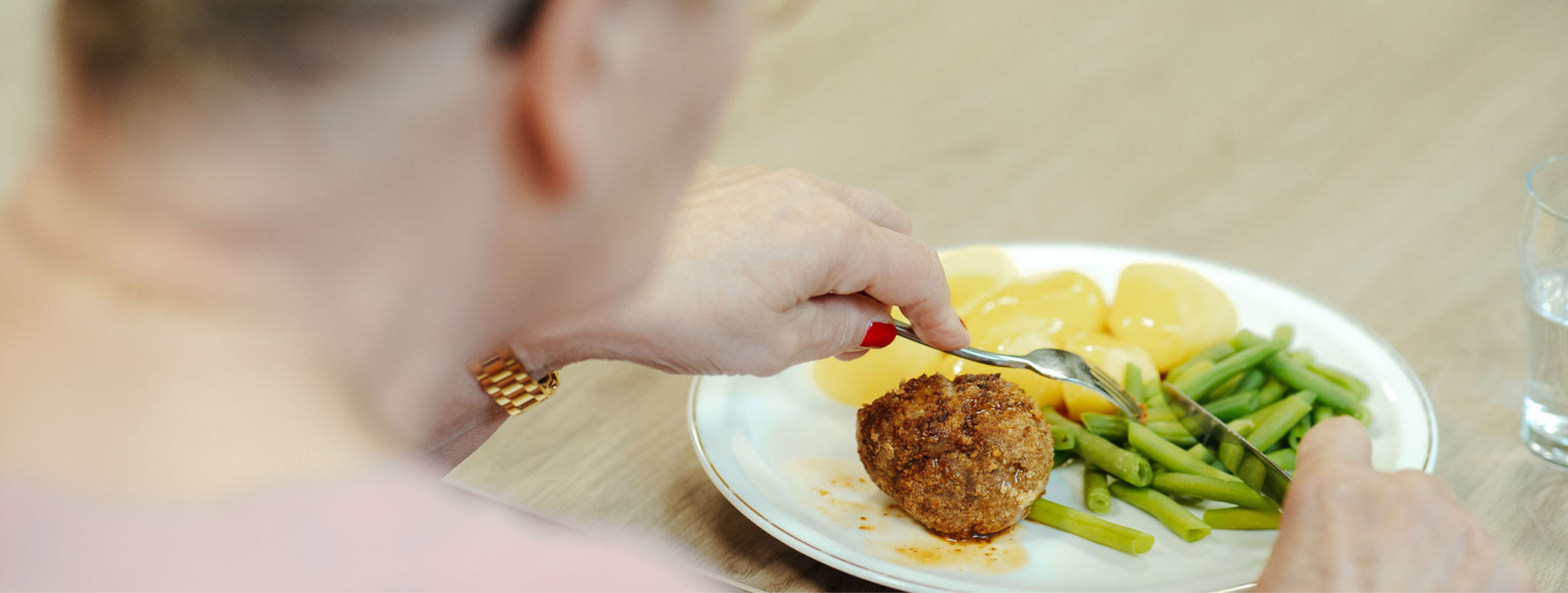 Zorgmedewerker serveert een versbereide maaltijd aan een bewoner in een zorginstelling